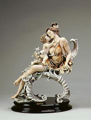 a sculpture of a woman and her child sitting on some white, tendril-like strcutures. the woman happily smiles at the child, who is looking up at her.